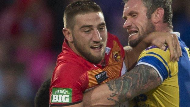 Catalan's Julian Bousquet (left) is held up by Jamie Peacock of Leeds.