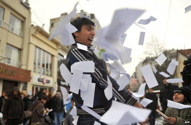 A man plays with fake euro banknotes at an anti-corruption rally in Istanbul, 26 February
