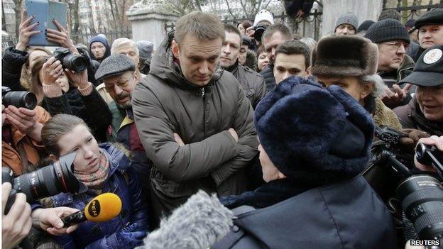 Alexei Navalny speaks to a police officer outside a courthouse in Moscow on 24 February