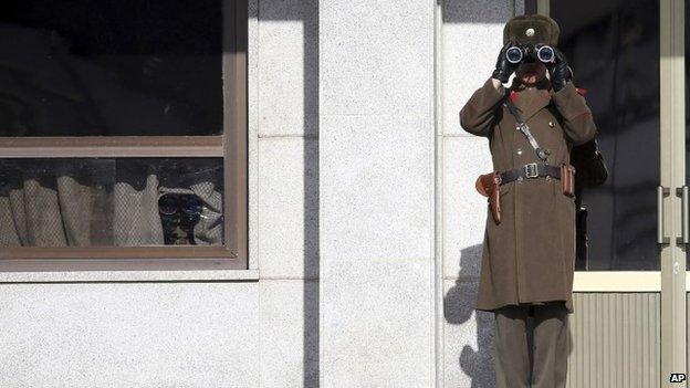 A North Korean soldier looks towards the South