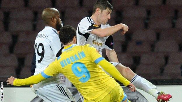 Gonzalo Higuain of Napoli scores despite the attention of Swansea defender Ben Davies