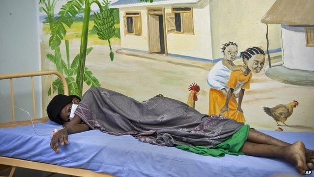 A newly-diagnosed HIV positive woman lies in the treatment ward of the Mildmay Uganda clinic on 27 February