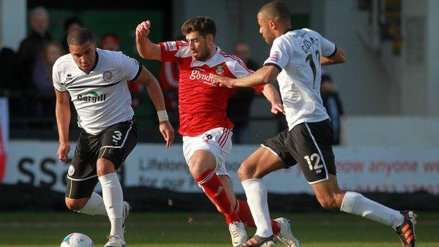Wrexham’s Mark Carrington tries to find a way past Chris Bush and Dominic Collins