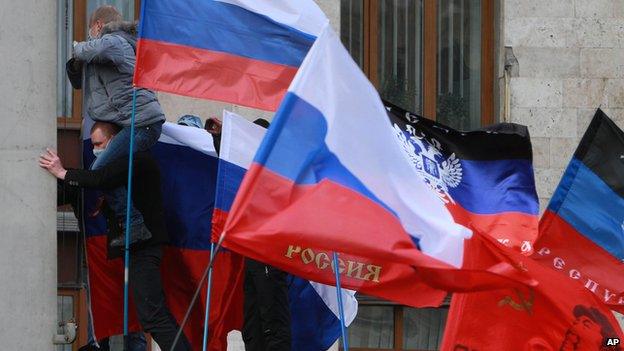 Pro-Russian activists hoist Russian flags over an administrative office in Donetsk, Ukraine, on 1 March 2014