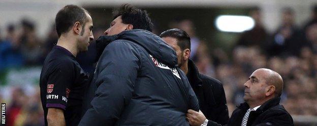 Atletico Madrid"s second coach Burgos argues with referee Delgado Ferreiro