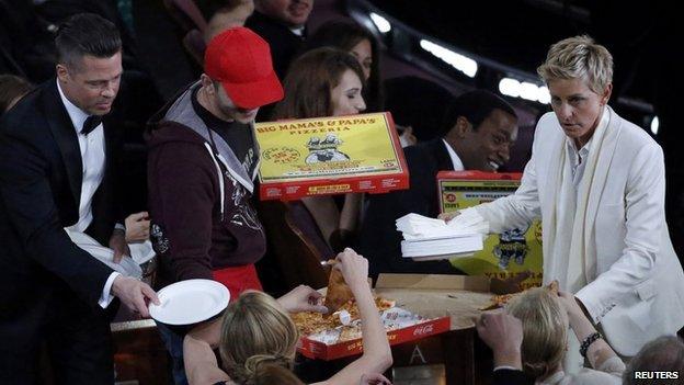 Ellen DeGeneres gives out pizza to the glittering audience, including Brad Pitt