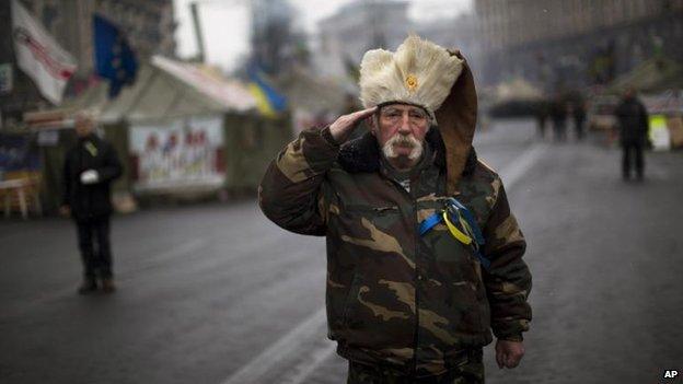 An anti-Yanukovych protester salutes as the Ukrainian national anthem is played at Kiev's Independence Square, 3 March