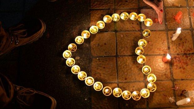 This picture taken on 2 March 2014 shows a Chinese mourner lighting candles at the scene of the terror attack at the main train station in Kunming, southwest China's Yunnan province