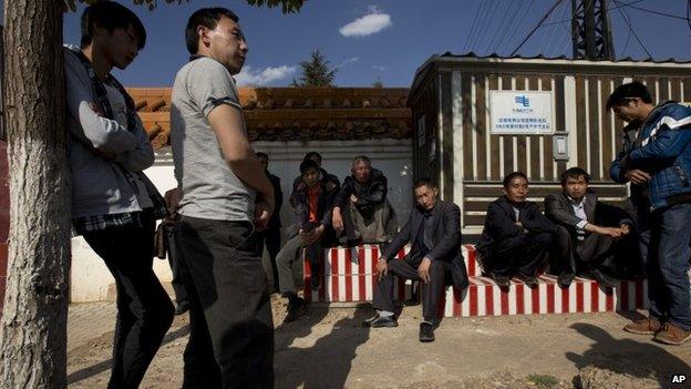 Relatives and friends of a victim killed in Saturday night's attack wait to see the victim's body outside a funeral home in Kunming