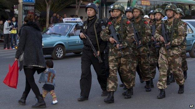 Armed policemen patrol a street near Kunming Railway Station (3 March 2014)