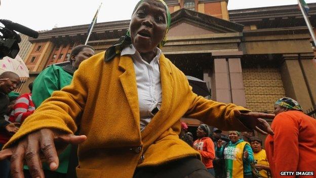 Members of the African National Congress Women's League sing in front of the courthouse ahead of the trial of Olympic and Paralympic track star Oscar Pistorius at the high court in Pretoria, 3 March 2014