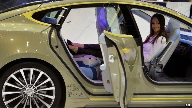 A woman poses inside the new Rinspeed XchangE concept car