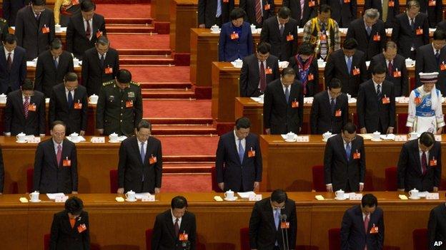 China's top leaders including Chinese President Xi Jinping, centre, bow their heads to observe a minute of silence during the opening session of the annual National People's Congress in Beijing's Great Hall of the People, China, 5 March 2014