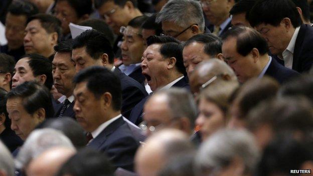 A delegate yawns as China's Premier Li Keqiang delivers the government work report during the opening ceremony of the National People's Congress at the Great Hall of the People in Beijing, 5 March 2014