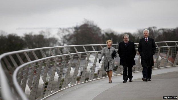 Former US President Bill Clinton walks with former Social Democratic Labour Party leader John Hume and Hume"s wife Pat across the Peace Bridge, in Londonderry