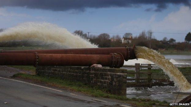 Environment Agency pipes pump flood water surrounding fields near Burrowbridge