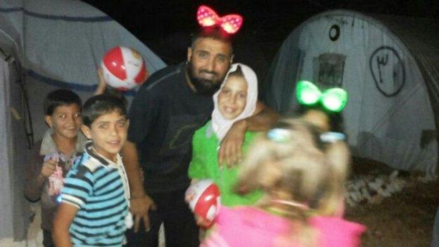 Majeed playing with children in a camp