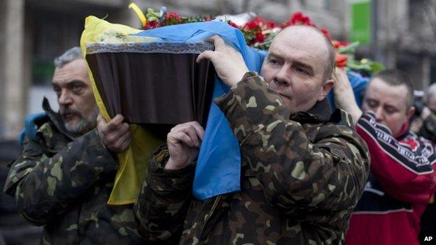 Pallbearers carry the coffin of Andryi Pozniak, killed two days ago near Kiev's Independence Square