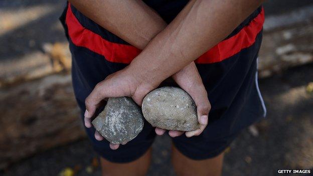 An anti-government activist holds rocks in a barricade set up by anti-government activists in San Cristobal, Tachira state, on 6 March 2014.