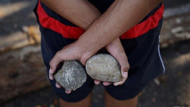 An anti-government activist holds rocks in a barricade set up by anti-government activists in San Cristobal, Tachira state, on 6 March 2014.