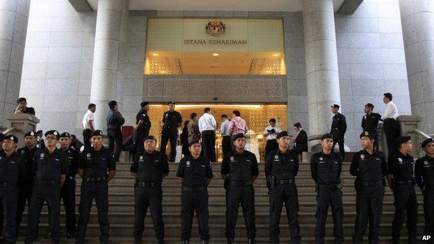 Malaysian police officers stand guard outside a courthouse in Putrajaya, Malaysia, Friday, March 7, 2014