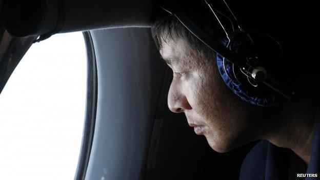 A military officer looks out of a window during a search and rescue mission onboard an aircraft belonging to the Vietnamese air force off Vietnam's Tho Chu island, 10 March 2014