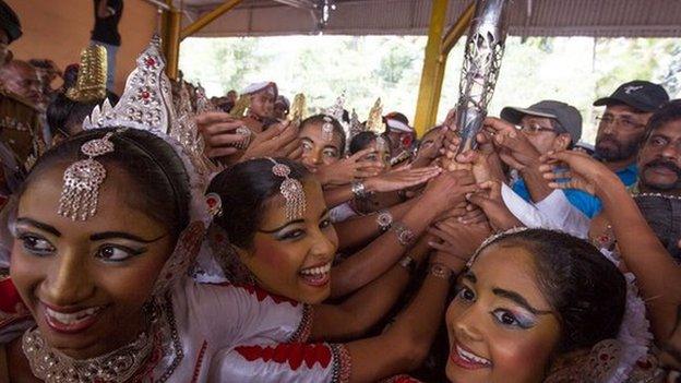 Traditional Sri Lankan dancers reach for the baton during arrival celebrations.