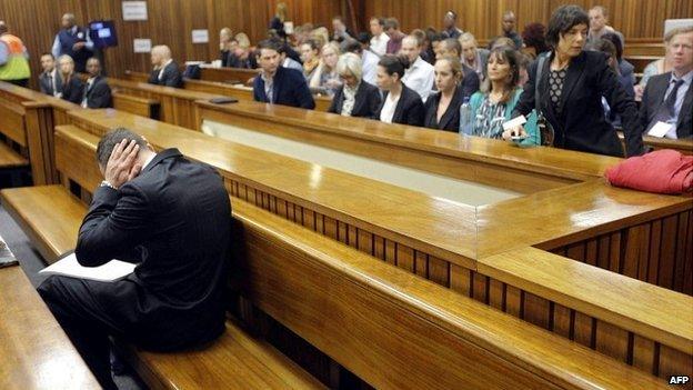 Oscar Pistorius sits in the dock with his head in his hands on day two of his trial