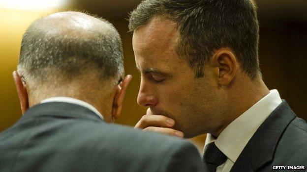 Oscar Pistorius speaks quietly with his uncle Arnold on day five of his trial