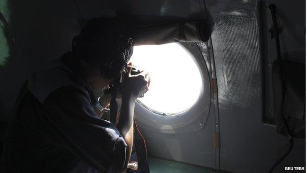 A Vietnamese Air Force officer takes photos from a search and rescue aircraft, 250km from Vietnam and 190km from Malaysia, 8 March