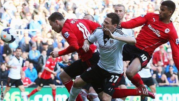 Sascha Riether of Fulham (27) scores an own goal for Cardiff City's third as he is challenged by Jordon Mutch (18) and Fraizer Campbell