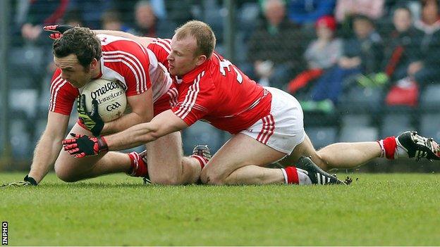 Derry's Emmet McGuckin holds on to possession as Michael Shields of Cork challenges