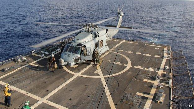 A U.S. Navy helicopter lands aboard Destroyer USS Pinckney during a crew swap before returning to a search and rescue mission for the missing Malaysian airlines flight MH370 in the Gulf of Thailand, Sunday, March 9, 2014