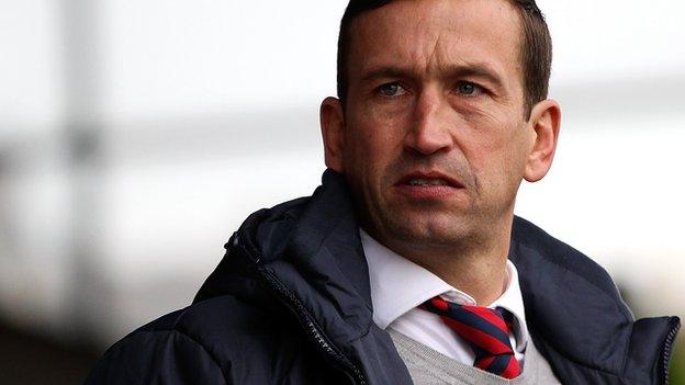 Justin Edinburgh looks on sadly.