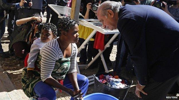 Interior Minister Jorge Fernandez Diaz speaks with an African migrant in a refugee centre in Melilla