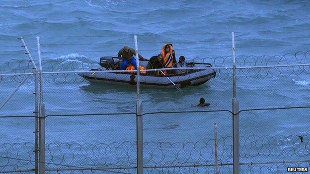 Moroccan soldiers remove a migrant from the water near Ceuta's border fence in 2014