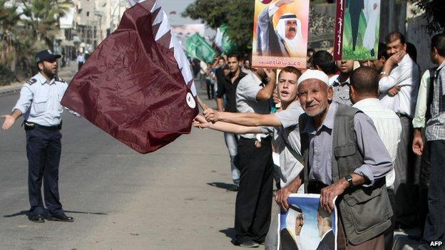 People wave Qatar's flag during a visit to Gaza by the then Emir, Sheikh Hamad bin Khalifa Al Thani