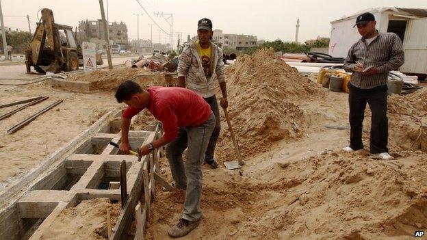 Palestinians work on a Qatar-funded road in Gaza City (8 April 2013)