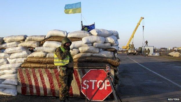 A Ukrainian soldier mans a checkpoint near the village of Salkovo, near the Ukrainian border with the Crimean region