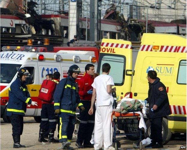 Rescue workers evacuate an injured person following the bombing at Atocha railway station in Madrid