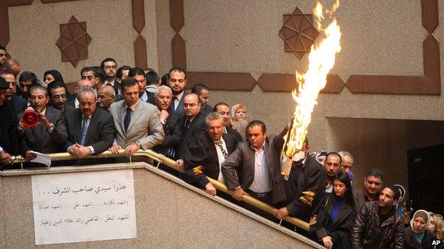 Jordanian lawyers and judges burn a representation of the Israeli flag during a strike inside the Palace of Justice in Amman, Jordan, on 11 March 2014.