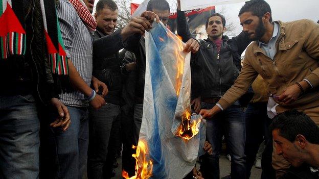 Jordanian demonstrators burn an Israeli flag during a protest in front of the parliament in Amman on 11 March 2014.