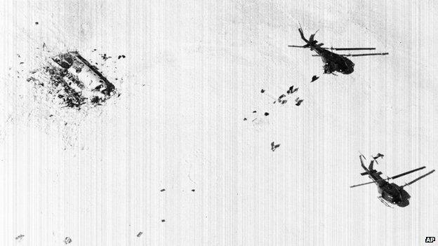 Survivors of the Uruguayan plane crash in the Andes walk across snow toward rescue helicopters in December 1972