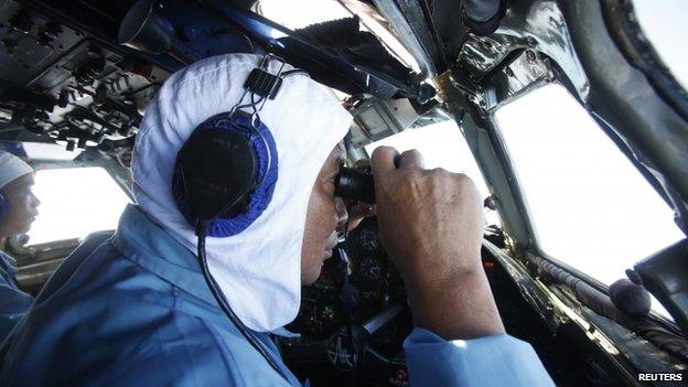 Deputy Commander of Vietnam 918 Air Brigade Senior Lieutenant Nguyen Tri Thuc (right) looks out for the missing Malaysia Airlines flight MH370 off Con Dao island, 12 March 2014