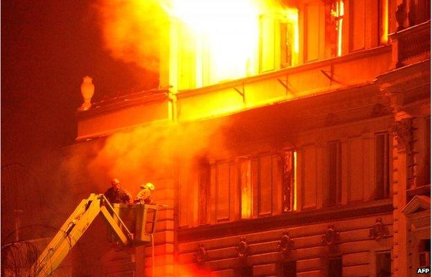 Bosnian firemen work to extinguish a fire caused by protestors who stormed a local government building in the the Bosnian capital Sarajevo, late on 7 February 2014