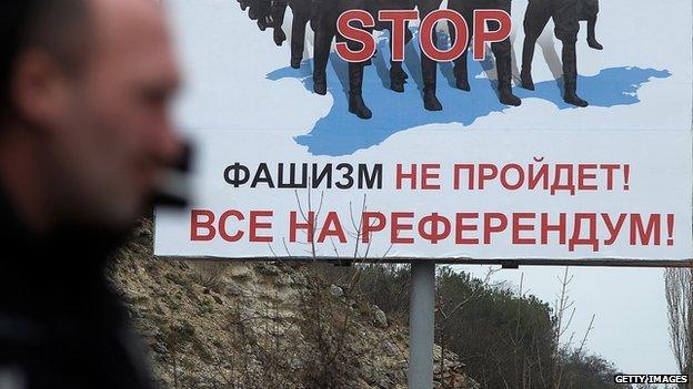 Man stands in front of billboard