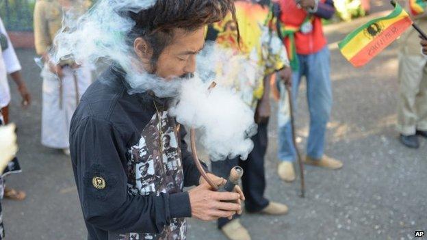 A man smokes a pipe of marijuana outside a museum dedicated to the memory of late reggae icon Bob Marley in Kingston on 6 February 2013