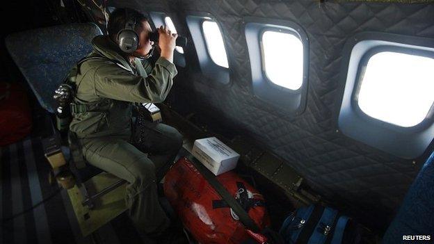 A member of the Malaysian air force looks out over the Straits of Malacca during the search operation