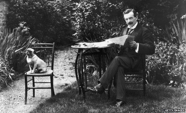 Welsh Liberal politician and future Prime Minister David Lloyd George (1863 - 1945) enjoys a quiet read of a newspaper in his garden with his faithful dog for company