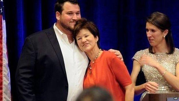 Democrat Alex Sink rests her head on her son's chest after conceding defeat in her congressional race on 11 March, 2014.